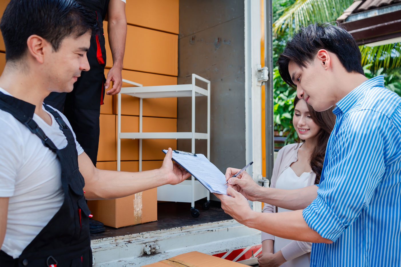 A person signing a document for house relocation trucking.